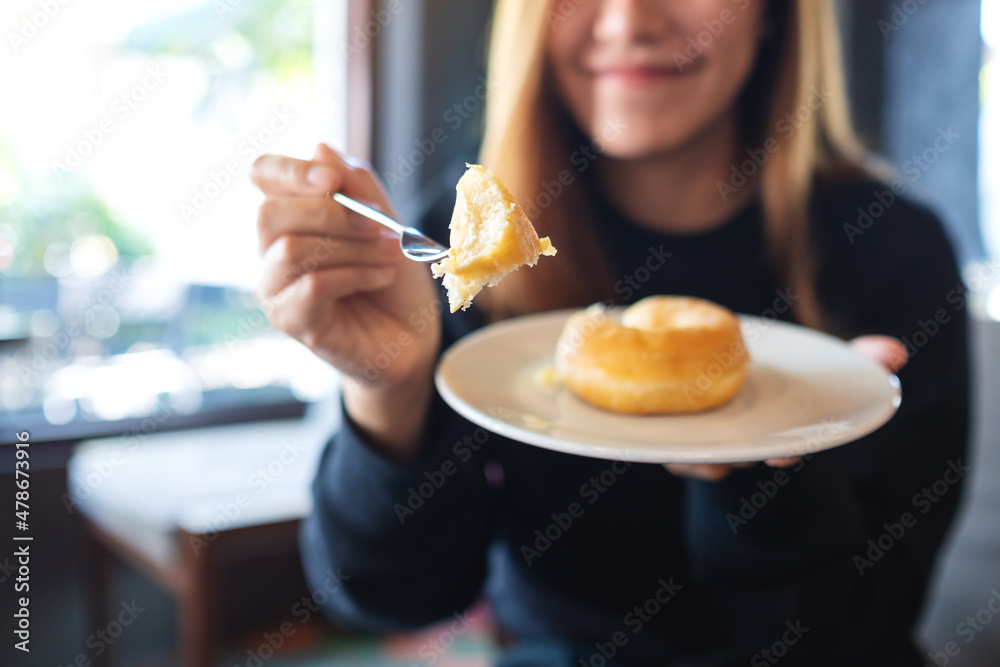 Closeup of a young woman holding and eating donut Closeup of a young woman holding and eating donut