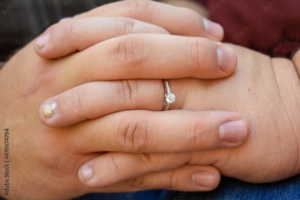 Closeup view of entwined fingers of an engaged couple. The entwined fingers show the love of the couple and how their lives will change. Closeup view of entwined fingers of an engaged couple. The entwined fingers show the love of the couple and how their lives will change.