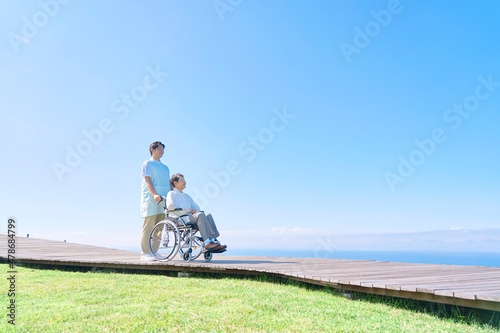 介護士と車椅子に乗る高齢者　屋外 photo