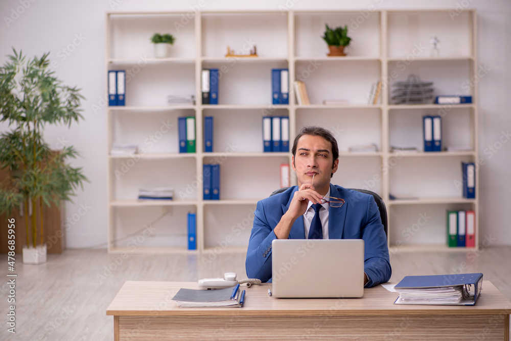 Young male employee sitting in the office Young male employee sitting in the office