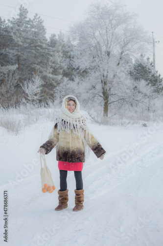 A girl with tangerines in a winter forest