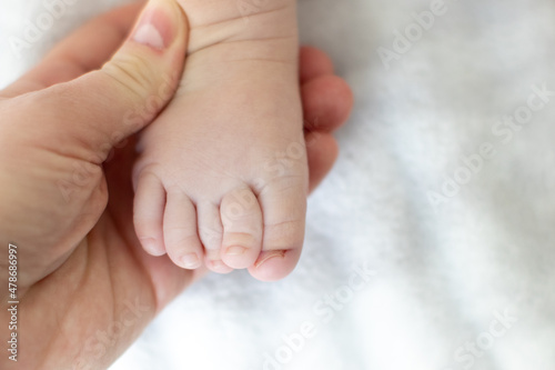 фотографія ingrown baby toe nail. A woman is holding her baby's foot.