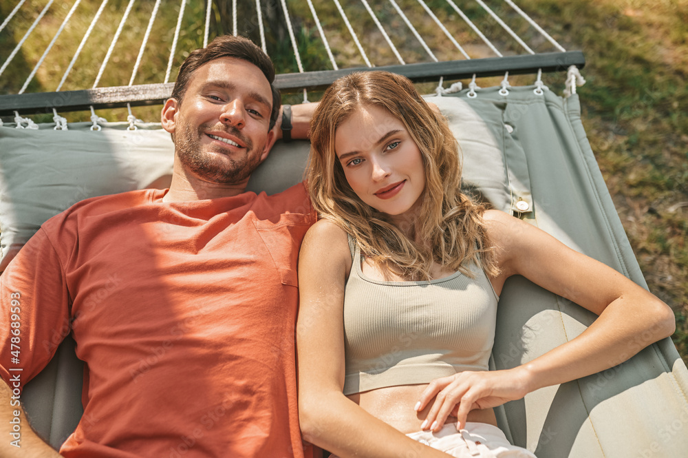 A man and a woman lying in a hammock and feeling relaxed