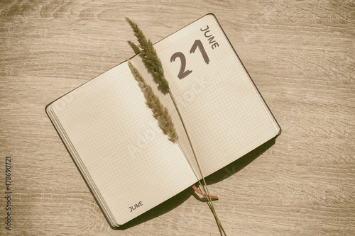 june 21. 21th day of month, calendar date.Blank pages of notebook are beige, with dried spikelets. Concept of day of year, time planner, summer month photo