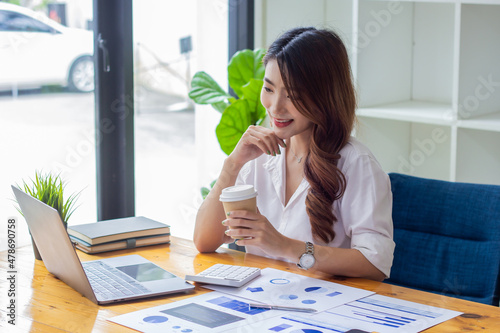 Businesswoman analyzing company sales in past years, woman sitting in chair holding coffee cup looking at financial documents on desk, accountant checking company numbers, new business concept.