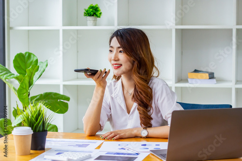 Businesswoman discussing company sales data last year on the phone, woman sitting in a chair looking at financial documents, accountant checking company numbers, concept of modern business people.