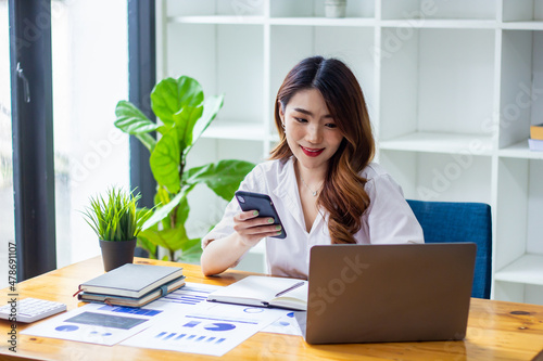 Businesswoman typing company sales data on computer, woman sitting in a chair looking at financial documents on desk, accountant checking company numbers, modern businessman concept.