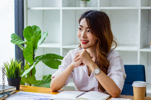 Businesswoman typing company sales data on computer, woman sitting in a chair looking at financial documents on desk, accountant checking company numbers, modern businessman concept.
