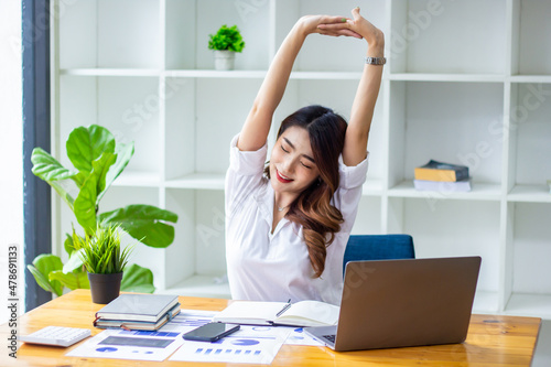 Businesswoman meditating and doing yoga due to fatigue from checking company balances, new business ideas.