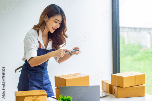 Small business owners are happy with company sales, cropped photo of woman photographing name in front of her box for delivery at online sales office, merchandising concept and modern businessman.