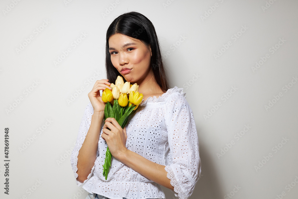 woman with Asian appearance in a white shirt flowers spring posing studio model unaltered woman with Asian appearance in a white shirt flowers spring posing studio model unaltered
