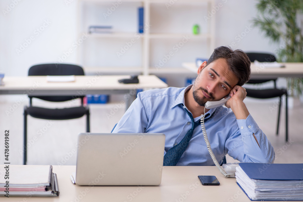 Young male employee working in the office Young male employee working in the office