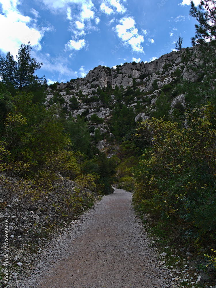 View of hiking path with diminishing perspective in a gorge near Calanque d'En-Vau in Calanques National Park near Cassis, French Riviera. View of hiking path with diminishing perspective in a gorge near Calanque d'En-Vau in Calanques National Park near Cassis, French Riviera.