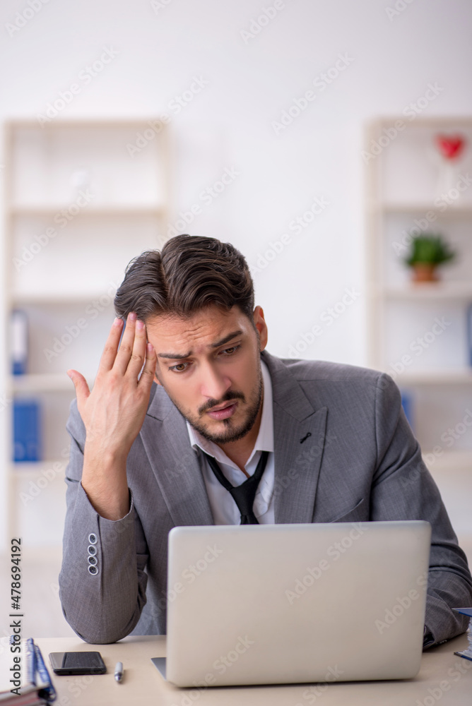 Young male employee working in the office Young male employee working in the office
