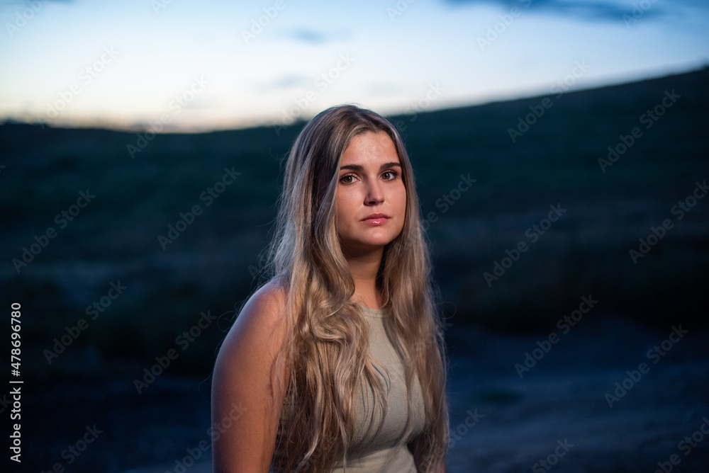 Portrait of a blonde serious woman while gets dark