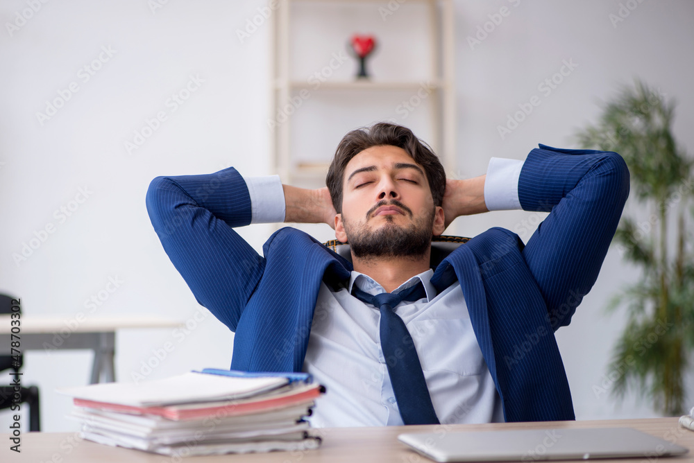 Naklejka premium Young male employee extremely tired in the office