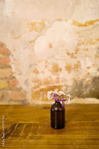 Wildflower in a small vase on the table in the rustic vintage cozy café