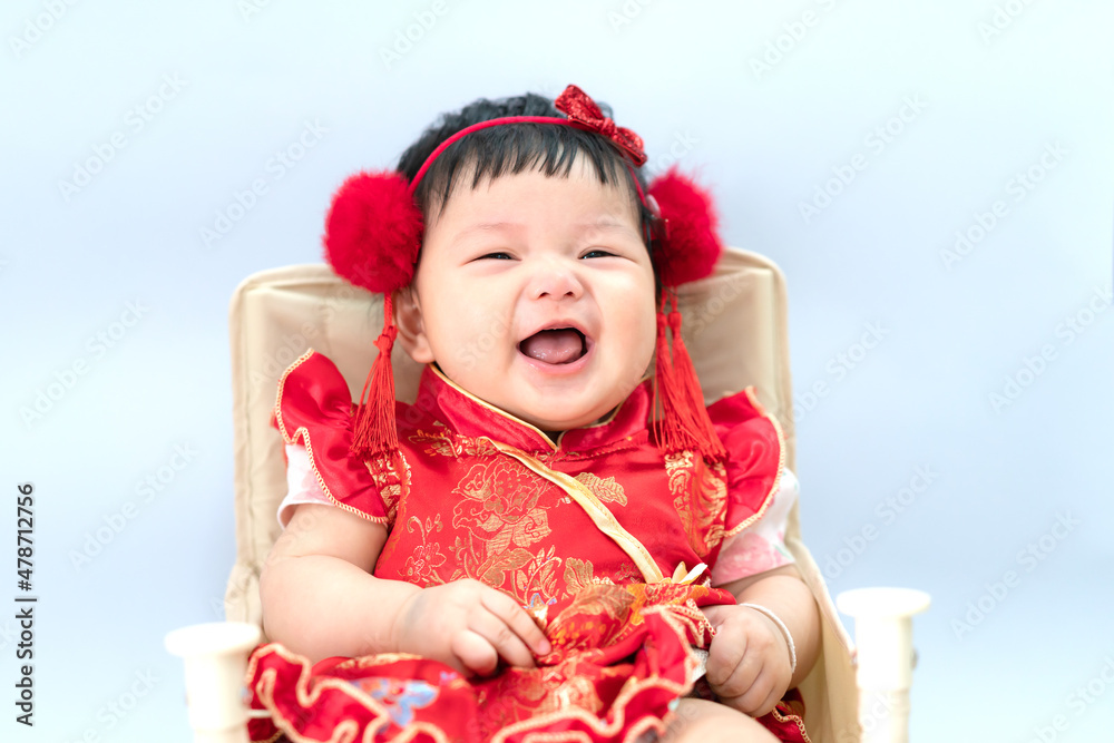 Happy cute infant baby girl in Chinese dress sitting in white living room. Cute Asian infant baby sitting in a white living room as concept of Chinese New Year. Happy cute infant baby girl in Chinese dress sitting in white living room. Cute Asian infant baby sitting in a white living room as concept of Chinese New Year.