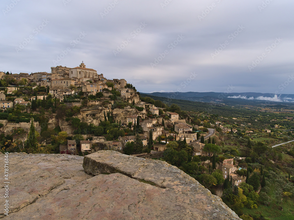 Beautiful view of historic village Gordes with old buildings located on a rocky hill above Luberon valley in Provence region, France on cloudy day.