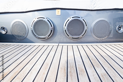 Several music speakers are integrated into the luxury yacht hull. Music speaker integrated into the sofa body on the teak deck of a luxury yacht.