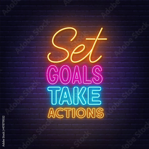 Foto Set Goals Take Actions neon lettering on brick wall background.