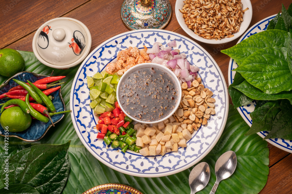 Miang Kham Or wild betel leaves Wrap Ingredients dried shrimps, peanuts, lime, chilli, roasted peanuts with sweet dipping sauce, Asian appetizer food. Miang Kham Or wild betel leaves Wrap Ingredients dried shrimps, peanuts, lime, chilli, roasted peanuts with sweet dipping sauce, Asian appetizer food.