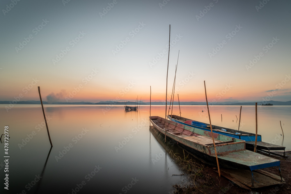 Two small boats moored on the shore of the lake. at sunset beautiful light