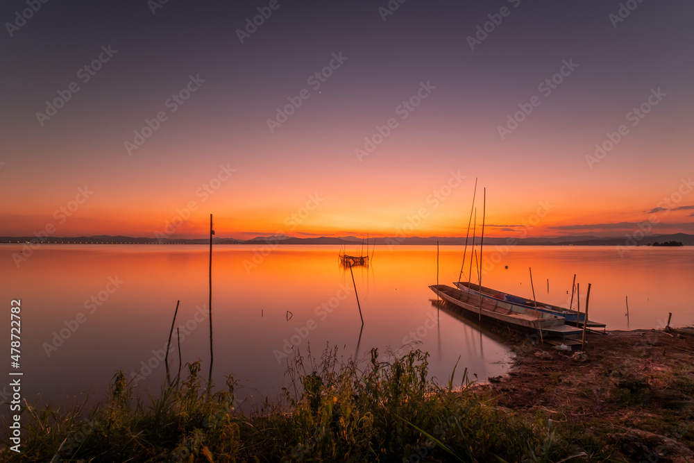 Two small boats moored on the shore of the lake. at sunset beautiful light