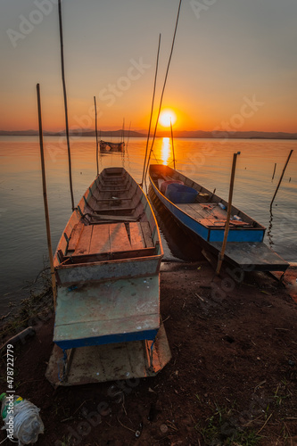 Two small boats moored on the shore of the lake. at sunset