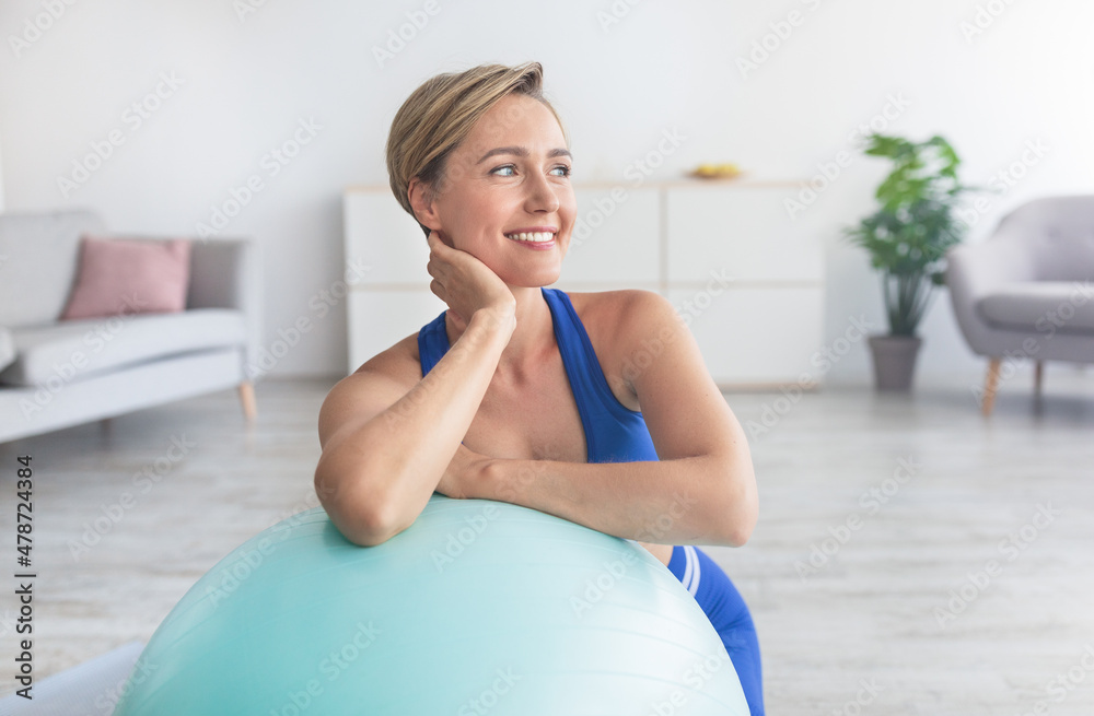 Smiling Sporty Woman Exercising Leaning On Ball At Home Smiling Sporty Woman Exercising Leaning On Ball At Home