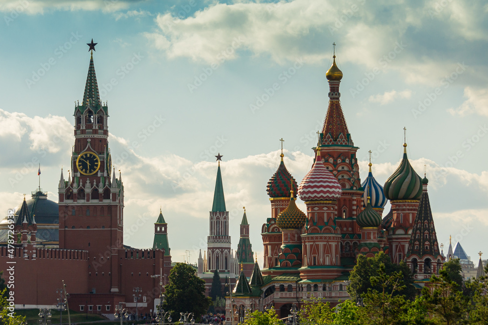 Moscow, Russia - June 16, 2019: View oна Spas Tower of Moscow Kremlin and St. Basil's Cathedral from of Zaryadye Park against blue sky. People stand on observation deck of building and take pictures. Moscow, Russia - June 16, 2019: View oна Spas Tower of Moscow Kremlin and St. Basil's Cathedral from of Zaryadye Park against blue sky. People stand on observation deck of building and take pictures.