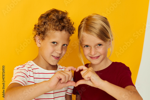 Portrait of cute children cuddling fashion childhood entertainment on colored background