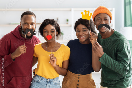 Happy black friends taking selfie, using funny accessories