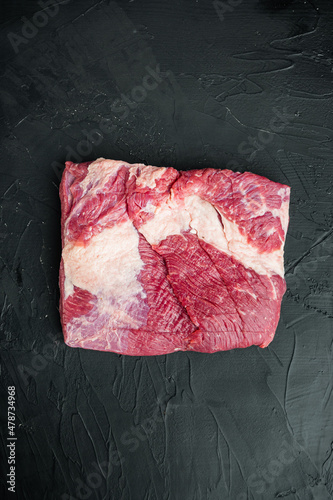Raw Beef belly, beef brisket meat, on black stone background, top view flat lay, with copy space for text