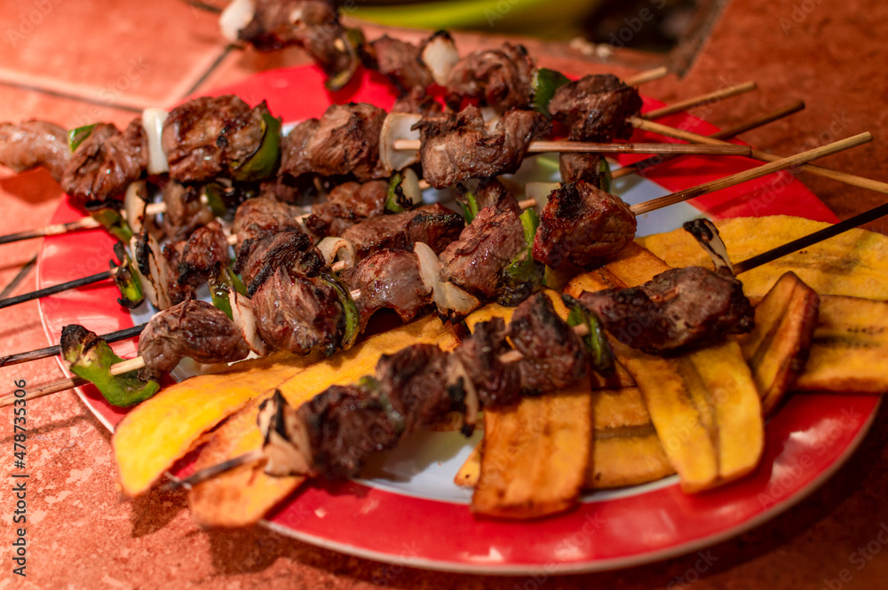 Roast beef skewers served on a silver, roast beef on skewers served with fried plantain Roast beef skewers served on a silver, roast beef on skewers served with fried plantain