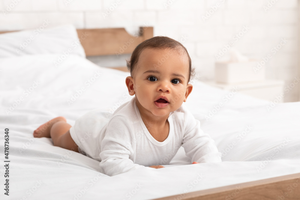 Cute African American Baby Infant In Longsleeve Lying In Bed Cute African American Baby Infant In Longsleeve Lying In Bed
