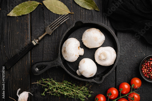 Fresh white champignon mushrooms, on black wooden table background