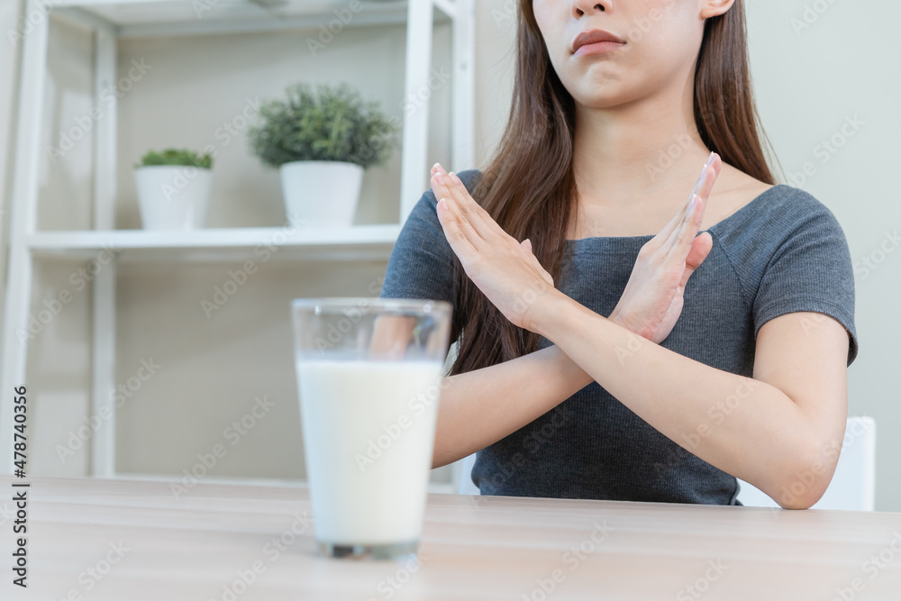 Allergy asian young woman, girl hand in deny, no or cross arm to avoid for drink milk at home, unhappy and bad stomach ache. Lactose intolerance and dairy food, health problem, belly suffer concept. Allergy asian young woman, girl hand in deny, no or cross arm to avoid for drink milk at home, unhappy and bad stomach ache. Lactose intolerance and dairy food, health problem, belly suffer concept.