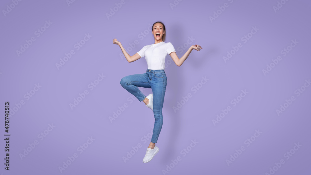 Cheerful Female Jumping Smiling To Camera Over Purple Background, Panorama