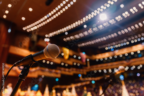 Fotografia Close up of microphone on the theater stage in concert hall and blurred lights b