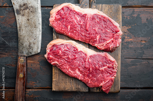 New York steak, raw beef meat , on dark wooden background, top view