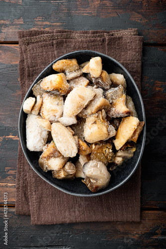 Frozen wild mushrooms, in bowl, on old dark wooden table background, top view flat lay