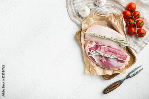 Raw duck breast , with herbs and ingredients, on wooden tray, on white stone  background, top view flat lay, with copyspace  and space for text photo