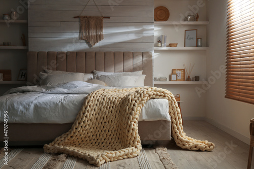 Soft chunky knit blanket on bed in stylish room photo