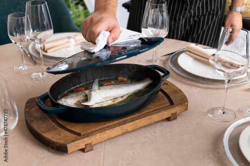 dorado fish in pan prepared for table in restaurant. pike perch defocused