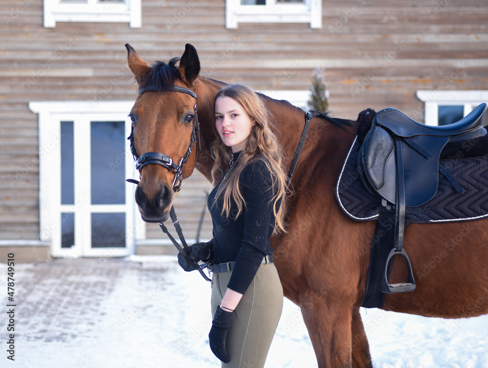 Obraz premium Young girl with horse on winter forest road