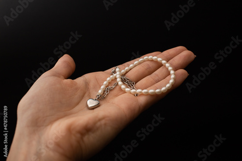 A girl holds in her hand a beautiful product made of silver and gold, a decoration accessory
