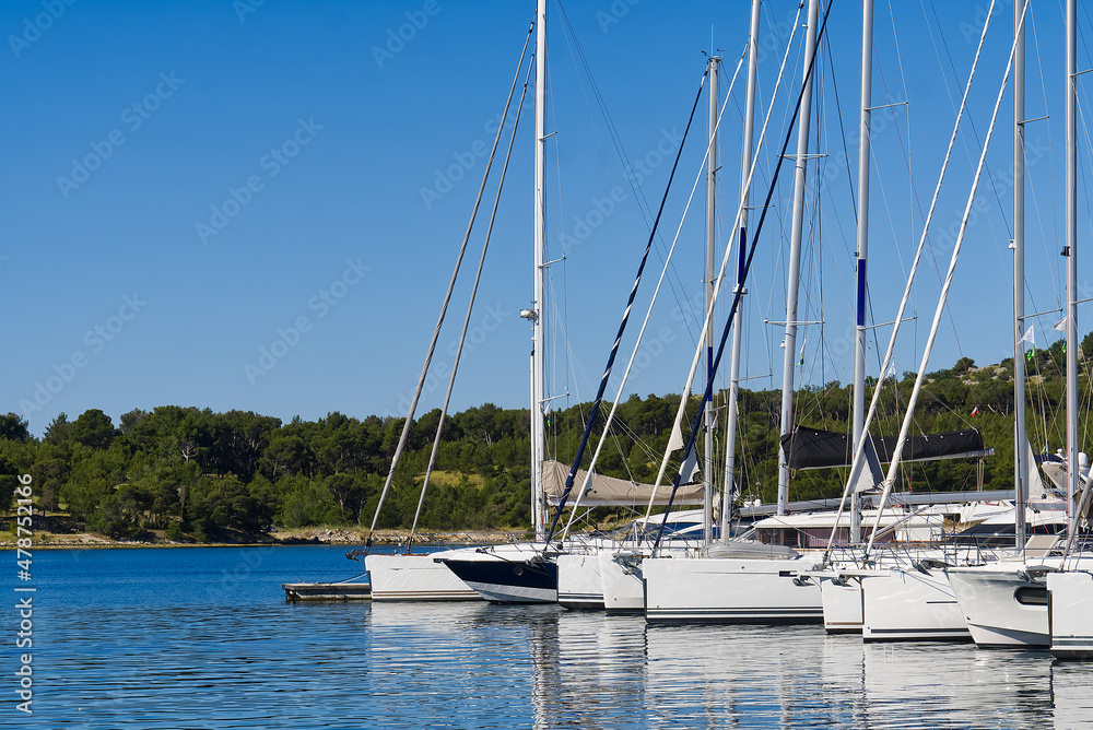 Obraz premium Yachts boats at harbor. Sailing yachts in marina. Sea coast pier. High class lifestyle. Yachting. Croatia, mediterranean marina