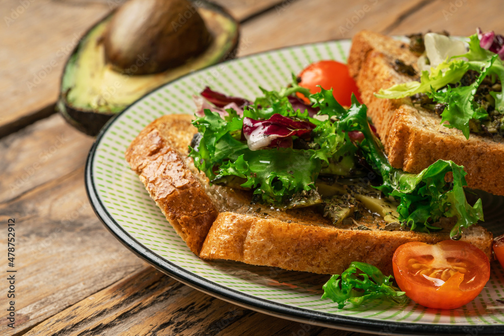 toast with avocado. vegetarian breakfast. Vegan or Vegetarian Toast with mashed avocado, arugula served on wooden board toast with avocado. vegetarian breakfast. Vegan or Vegetarian Toast with mashed avocado, arugula served on wooden board