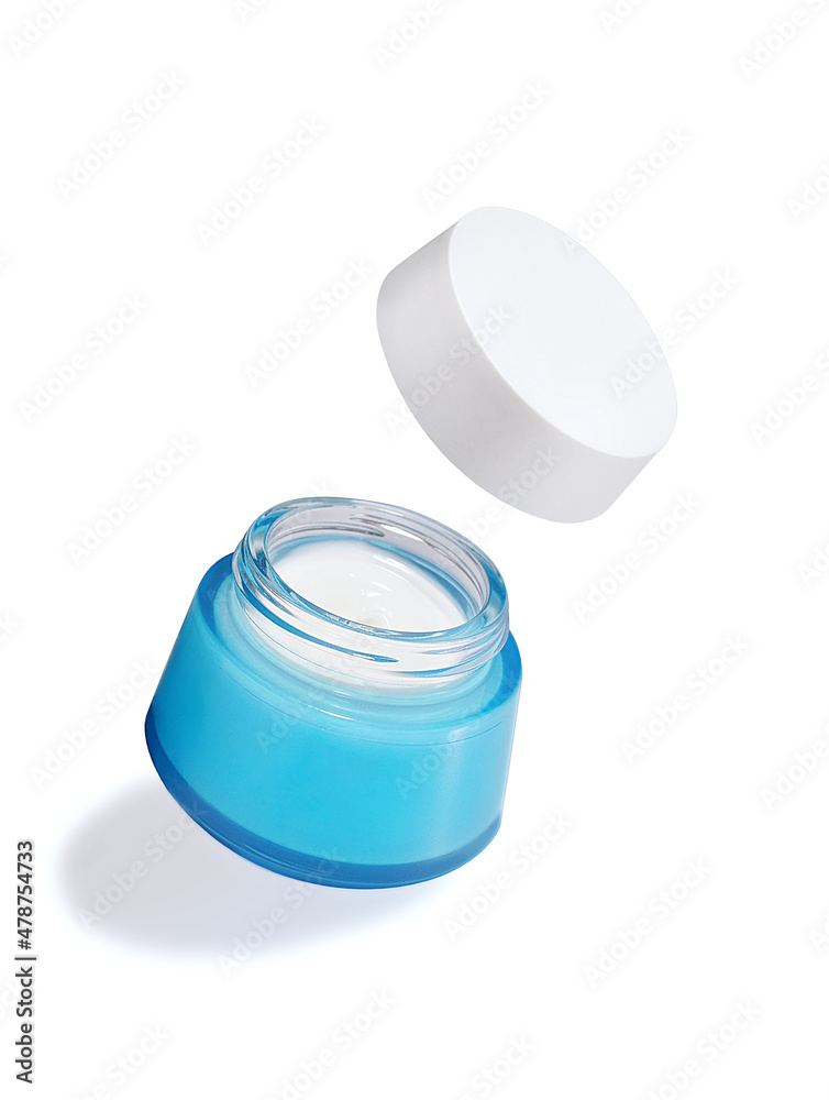 Open jar with cosmetic cream flying on white background. Levitation. Body care creative concept. Open jar with cosmetic cream flying on white background. Levitation. Body care creative concept.